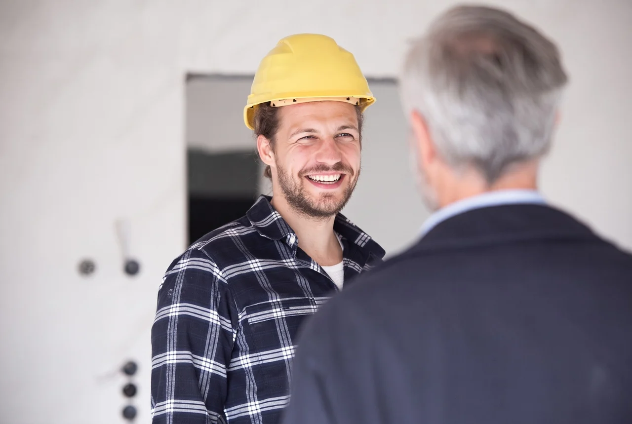Handwerker im Gespräch mit einem Bauherrn