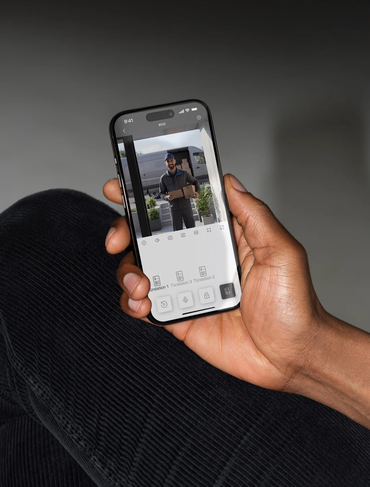 Hand hält ein Smartphone mit dem Live-Bild der Türstation