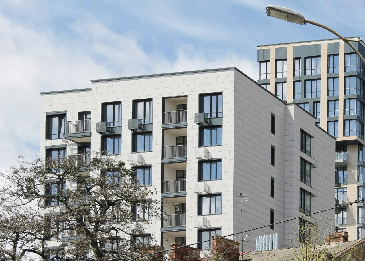 Mehrgeschossiges Wohnhaus mit Balkonen von der Straße aus